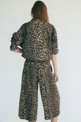 Pantalón palazzo de corte holgado con estampado de leopardo, piernas amplias, pinzas y bolsillos laterales.