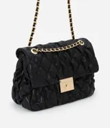 Cartera shoulder grande color negro con textura acolchada y cierre con broche metálico dorado. Tiene asa de cadena dorada con apliques de cuero.