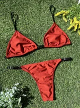 Bikini color ladrillo con corpiño triangular con breteles de elástico y bombacha colaless regulable. El corpiño tiene abertura para agregar tazas. Hecho con lycra premium metalizada.