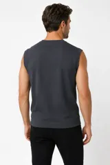 Sweater sin mangas de punto color gris oscuro, con cuello redondo y diseño ajustado.