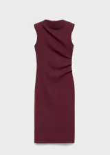 Vestido midi de color bordó, sin mangas, con cuello redondo y diseño entallado. Presenta un detalle de fruncido lateral en la cintura y cierre posterior.