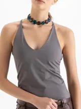 Top gris de punto, ajustado al cuerpo, con escote en V pronunciado y breteles finos que se unen en la espalda.