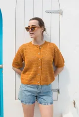 Saco tejido calado color ocre, con mangas al codo y botones de coco. Tiene grifa de cuero en la espalda.