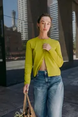 Chaqueta de punto color azul marino, con cuello redondo, manga larga y cierre frontal con botones. Los acabados son en rib a tono.