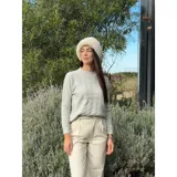 Sweater de punto color blanco marfil, con diseño de trenzas frontales, cuello redondo y mangas largas con puños elásticos acanalados.