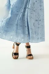 Sandalias de cuero color beige con plataforma y taco cuadrado de madera. Presentan una tira frontal ancha y una tira ajustable en el tobillo con hebilla metálica plateada.
