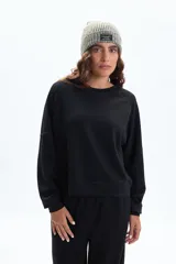 Buzo deportivo negro de manga larga, con cuello redondo y corte holgado.