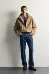 Jeans de denim azul oscuro sin lavados, corte recto con raya frontal planchada, tiro medio, cinco bolsillos y cierre frontal de botonadura. Colección especial Aaron Levine x Zara.