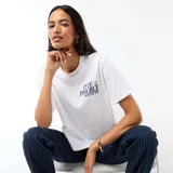 Camiseta blanca de manga corta con cuello redondo y corte estándar. Presenta un estampado pequeño en el pecho con el texto 'Cute Trouble Stitch 626' y una ilustración del personaje Stitch.