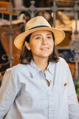 Sombrero de estilo fedora confeccionado en material tejido color tostado, con una franja decorativa negra alrededor de la copa.