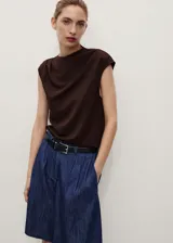 Short de denim azul con tiro medio, trabillas, cierre frontal con cremallera y botón, pinzas delanteras y bolsillos laterales.