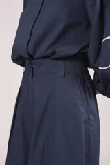 Pantalon de corte ancho y tiro alto, color azul marino, con bordados florales en color crema en la parte inferior de las piernas.