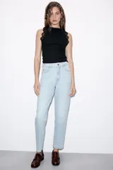 Top negro de punto rib con cuello halter, sin mangas y detalles de encaje a tono en las sisas.