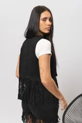 Chaleco marrón de gamuza con flecos y tachas plateadas.