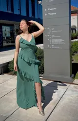 Vestido largo color verde con breteles finos, escote en V y volados diagonales.