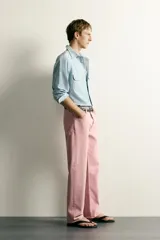 Jeans straight fit de denim de algodón color rosado, con diseño de cinco bolsillos, tiro medio y corte de pierna recta desde la cadera hasta el tobillo. Cuenta con cierre frontal de cremallera y botón metálico.