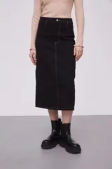 Falda midi de jean color negro, de tiro alto y corte recto. Presenta costuras a la vista en color ocre y cierre frontal con botón y cremallera.