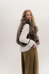 Chaleco de piel sintética en tono marrón, con diseño de pelo largo y voluminoso, ideal para superposiciones.