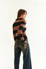 Top de manga larga con diseño de rayas horizontales en tonos negro y marrón, cuello polo con cierre de botones y bordado pequeño en el pecho.