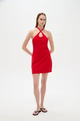 Vestido corto rojo de viscosa, ajustado al cuerpo, con cuello halter cruzado y detalle de abertura en el escote.