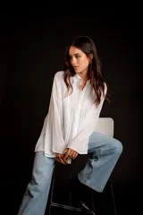 Camisa rosada con detalles de broderie en la parte delantera y mangas anchas.