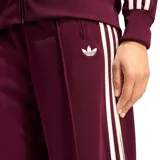 Pantalon deportivo Adidas modelo Firebird, color bordó, con diseño de pierna recta, cintura elástica, bolsillos laterales con cierre y las icónicas tres tiras blancas en los laterales.