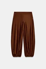 Pantalón de tiro medio confeccionado en terciopelo color marrón, con diseño bombacho, bolsillos delanteros y bajos con puño elástico. Cuenta con cierre lateral oculto.