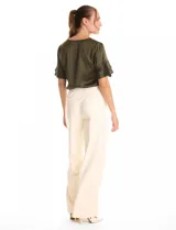 Blusa de satén color verde oliva, con cuello redondo y escote en V. Presenta mangas cortas con tres capas de volados superpuestos.