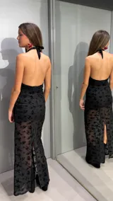 Vestido largo negro de cuello halter con escote en V pronunciado, confeccionado en tejido translúcido con diseño flocado de terciopelo con motivo floral.