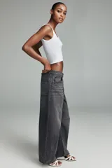 Jeans de mujer color beige claro, tiro medio, estilo balloon baggy con pierna ancha y largo completo. Presenta costuras visibles y un lavado que le da un aspecto desgastado.