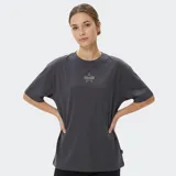 Remera de algodón color gris oscuro, con corte holgado y cuello redondo. Presenta un estampado frontal pequeño con forma de estrella y el logo de la marca en el centro.