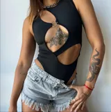 Body negro de corte ajustado con diseño cut-out en el pecho y abdomen, unido por una argolla metálica central. Presenta cuello redondo y estilo sin mangas.