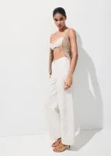 Jeans blancos de tiro medio con diseño wide leg y bordado de flores tono sobre tono en las perneras. Cuentan con diseño clásico de cinco bolsillos, trabillas y cierre frontal de botón y cremallera.