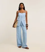 Pantalón wide leg de cintura alta, confeccionado en jeans celeste, con trabillas en la cintura, cierre tradicional, bolsillos y recortes delanteros de frisos.