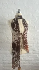 Top halter con estampado animal print de vaca, con tiras finas que se atan en la nuca y en la espalda.