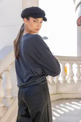 Pantalón negro de cuero sintético, corte recto y tiro alto, con bolsillos laterales y traseros.