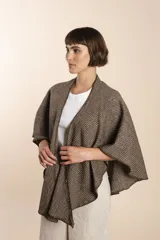 Ruana corta de lana color marrón con terminación de crochet hecho a mano. Prenda cómoda, versátil y fácil de combinar.