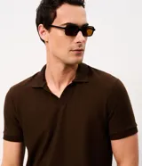 Remera polo de hombre en color marrón, confeccionada en tejido texturizado con mezcla de algodón y poliéster, de manga corta y cuello abierto sin botones.