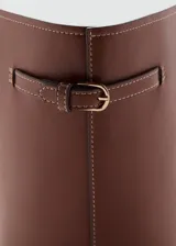 Bolso tipo tote marrón de gran tamaño, con diseño estructurado, dos asas superiores y detalles de hebillas en los laterales. Cuenta con forro interior y cierre de botón magnético.