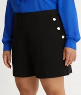 Bermuda de crepé color blanco, de corte holgado y tiro alto, con pliegues frontales y bolsillos laterales con detalle de botones. Confeccionada en poliéster y elastano.