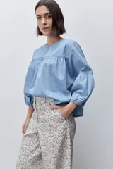 Pantalón de tiro alto con silueta amplia y piernas rectas, confeccionado en algodón con estampado floral. Cuenta con cierre frontal de botón y cremallera, y bolsillos laterales funcionales.