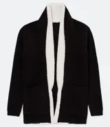 Chaqueta de tricot color negro con interior de pelo sintético blanco, corte recto, manga larga y bolsillos frontales. Marca Blue Steel.