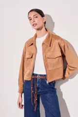 Campera corta color marrón claro, de gamuza sintética, con cierre frontal, cuello clásico, bolsillos con solapa y corte ajustado.