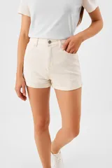 Short de jean de tiro alto con ajuste al cuerpo, diseño de cinco bolsillos y ruedo con dobladillo.