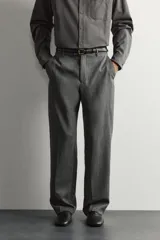 Pantalón de traje gris de corte relaxed fit, confeccionado en pura lana, con bolsillos laterales, bolsillos traseros de doble vivo y raya marcada en las piernas.
