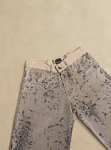 Pantalón de tiro medio con silueta recta levemente acampanada, confeccionado en gabardina con estampado animal print tipo cowhide. Cuenta con cierre frontal, botón y bolsillos funcionales.