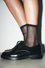 Zapato tipo blucher de estilo clásico con cierre mediante cordones. Presenta un acabado en punta redonda y suela con plataforma.