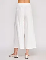 Pantalón palazzo de lino y viscosa, color blanco, de tiro alto y silueta amplia. Presenta pinzas frontales, bolsillos laterales y cierre con botón.