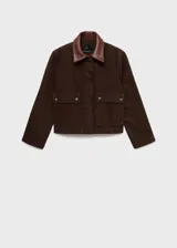 Chaqueta corta de algodón en color marrón oscuro, con cuello de efecto piel en tono contrastante. Presenta cierre frontal con cremallera y botones a presión, además de dos bolsillos frontales con solapa y cierre de botón.