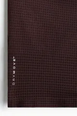 Remera deportiva color marrón oscuro con tecnología DryMove, de manga corta raglán, cuello redondo y paneles microperforados en los laterales y hombros.